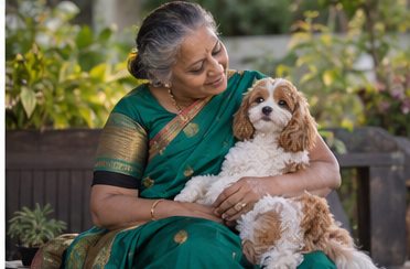 A woman in a green sari holds a small white-and-brown dog outdoors